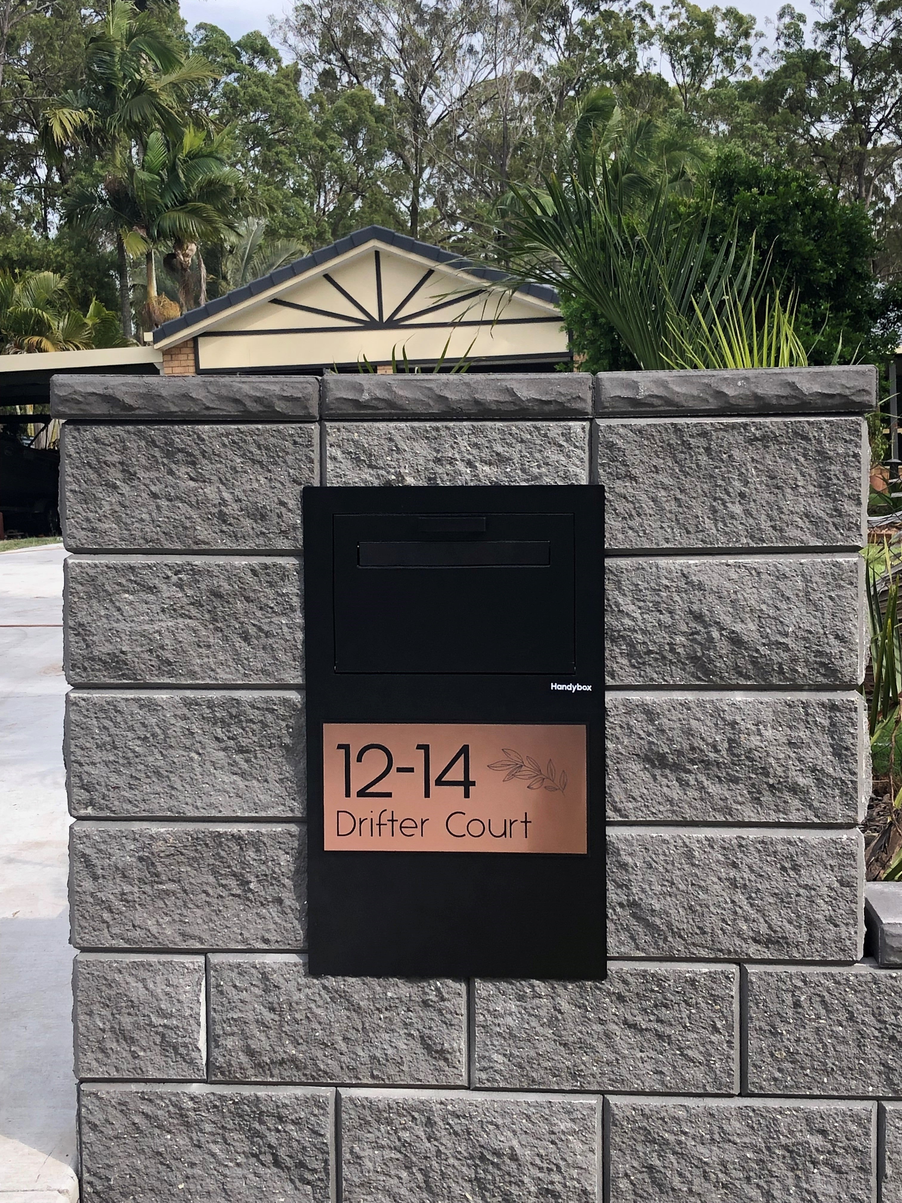 The Tassie Devil Black Colour fence mounted parcel box by Handybox Parcel Boxes with custom copper address plaque